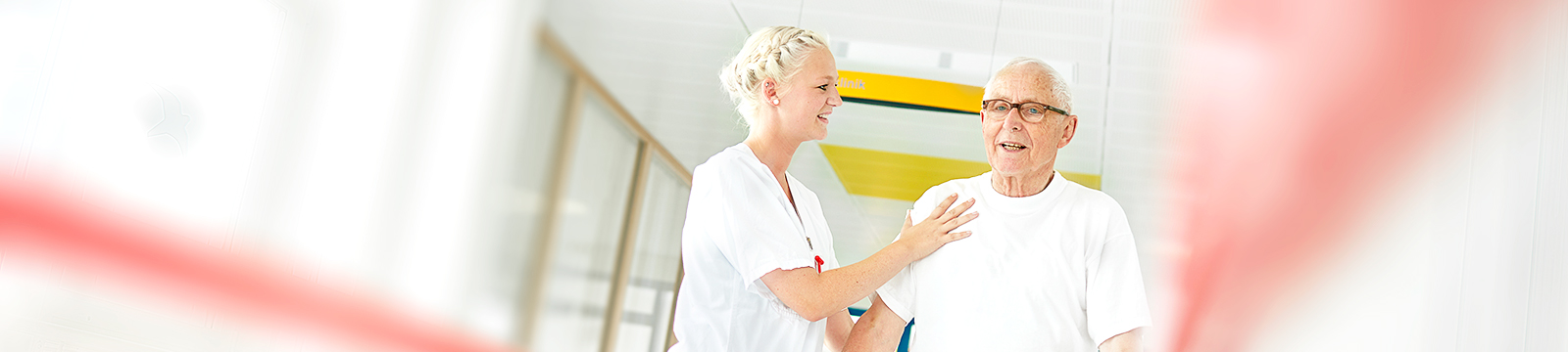 Das Bild zeigt, eine Krankenpflegerin die einen Patienten mobilisiert