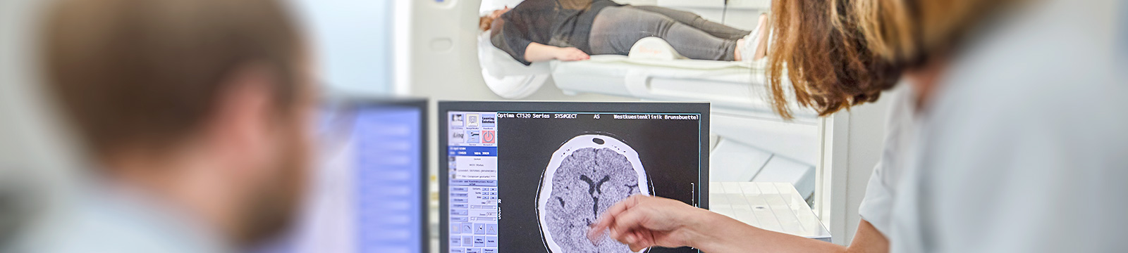 Das Bild zeigt, einen Mitarbeiter und eine Mitarbeiterin der Klinik für Innere Medizin in Brunsbüttel, diese schauen sich ein herausgegebenes MRT oder CT Bild an