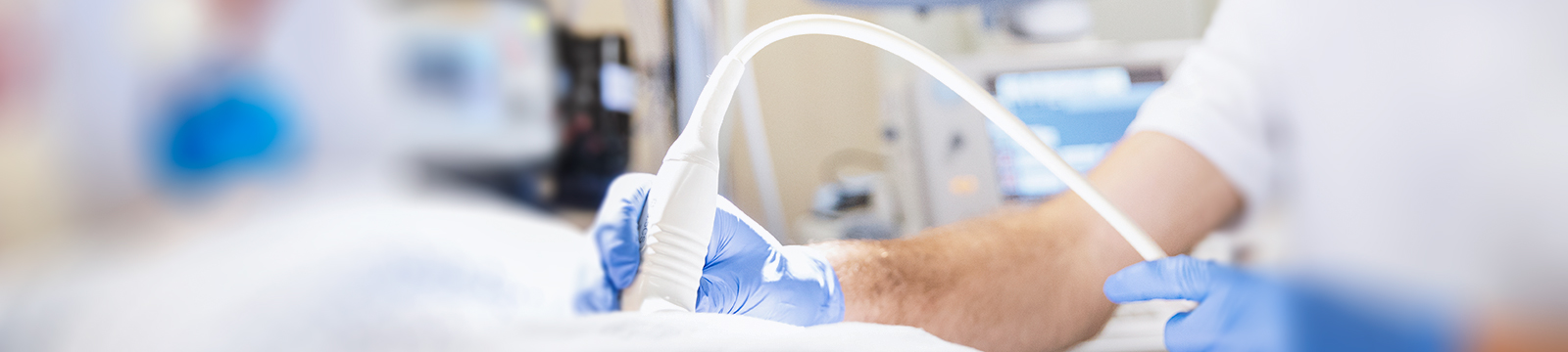 Das Bild zeigt, einen Mitarbeiter der Klinik für Notfallmedizin, führt ein Ultraschall bei einem/einer Patient/Patientin durch