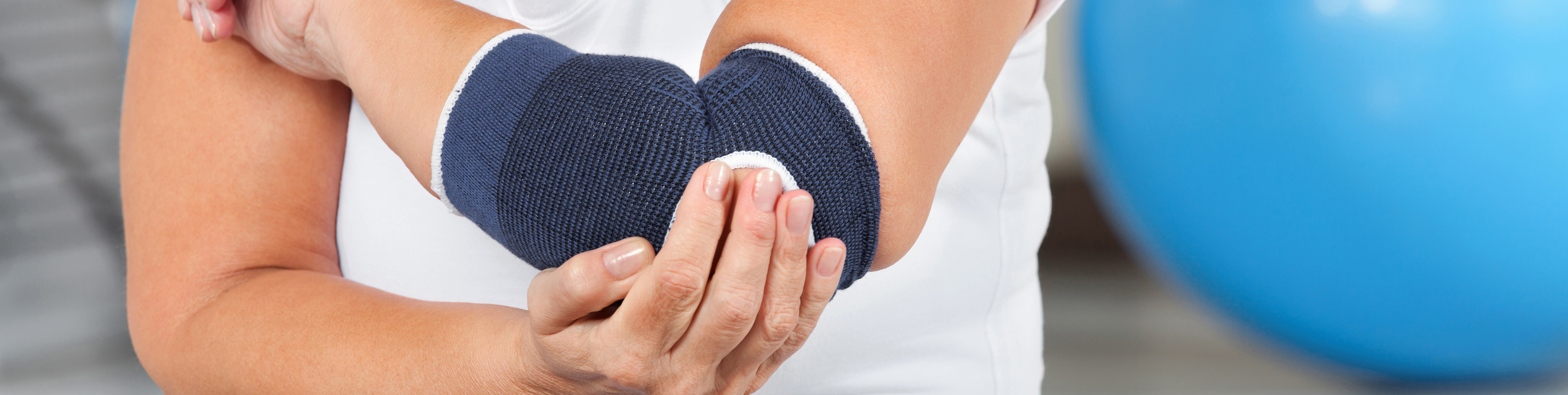 Das Bild zeigt, eine Patientin die eine Bandage um den Ellenbogen trägt
