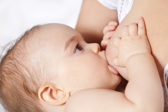 Baby wird an der Brust gestillt. 