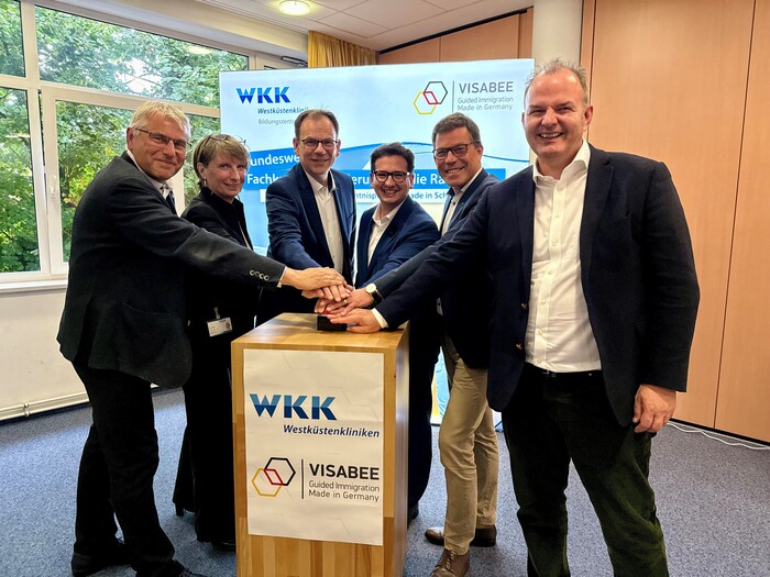 Drückten gemeinsam den symbolischen Startknopf für die Kooperation: Der Medizinische Geschäftsführer der Westküstenkliniken, Dr. Martin Blümke, die Pädagogische Leiterin des Bildungszentrums der Westküstenkliniken, Iris Gebh, Gesundheitsstaatssekretär, Dr. Olaf Tauras, Geschäftsführer der VISABEE GmbH, Bastian Mahmoodi, der Präsident der IHK zu Kiel, Knud Hansen und der Vorsitzende der Geschäftsführung der Arbeitsagentur Nord, Markus Biercher.