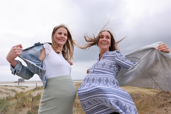Zwei Frauen jeweils mit einem Babybauch in den Dünen von St. Peter-Ording. 