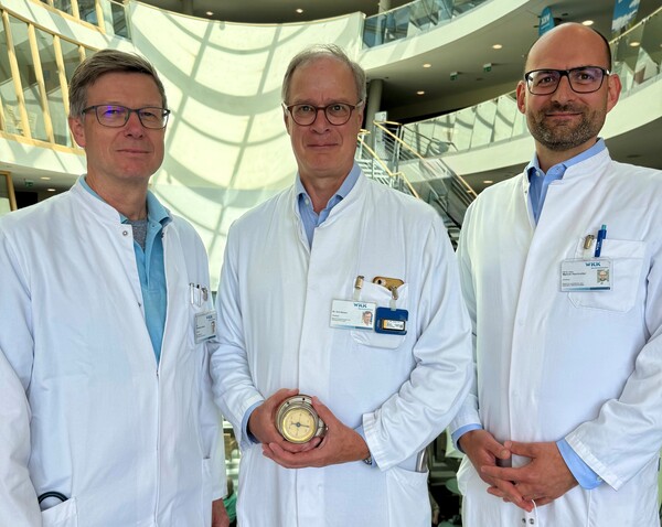 Der Ärztlichen Direktor Dr. Urs Nissen (mitte) mit seinen beiden Stellvertretern Dr. Reinhard Jensen (l.) und Privatdozent Dr. Marcel Hochreiter. Es ist Tradition, dass der amtierende Ärztlicher Direktor für die Dauer der Amtszeit die alte Uhr erhält, die Dr. Nissen in den Händen hält.